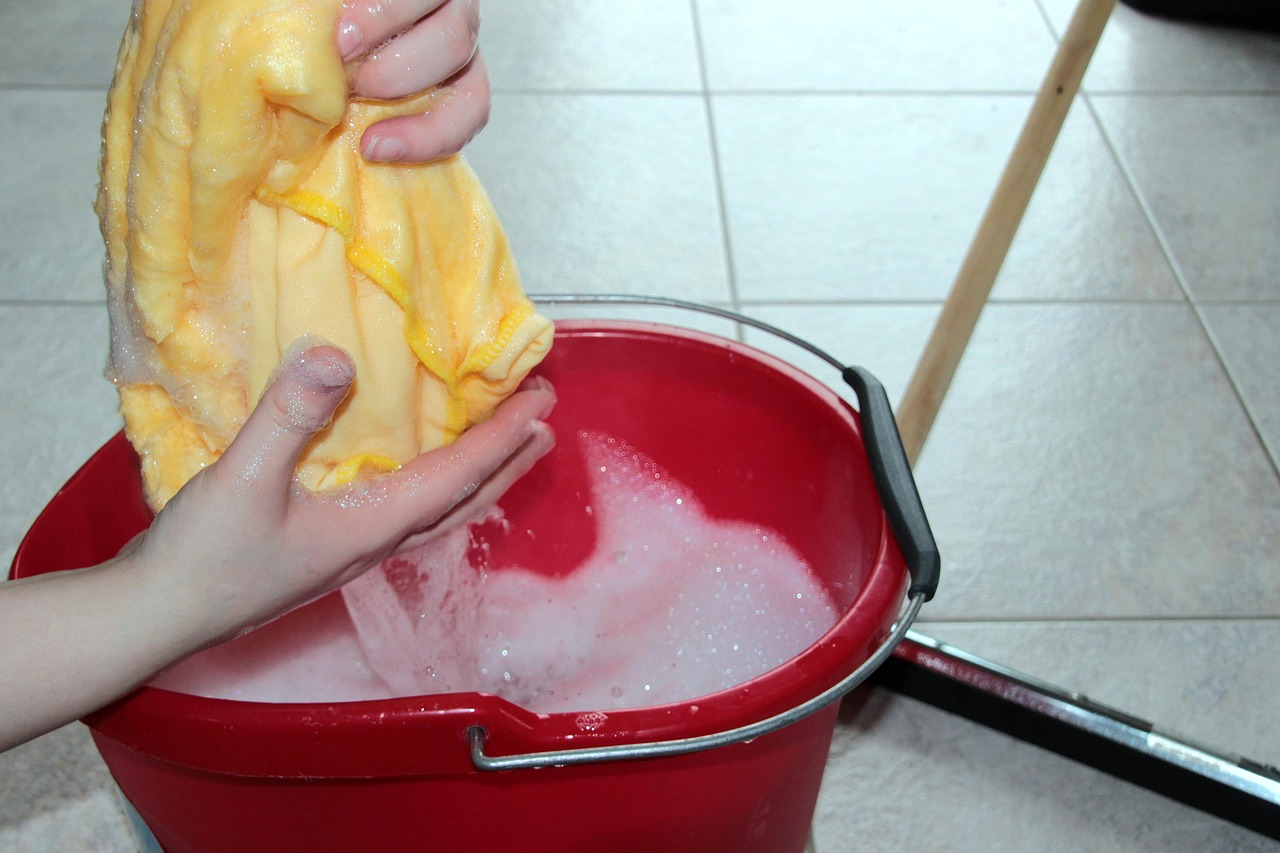Wringing a soapy cloth into a bucket.