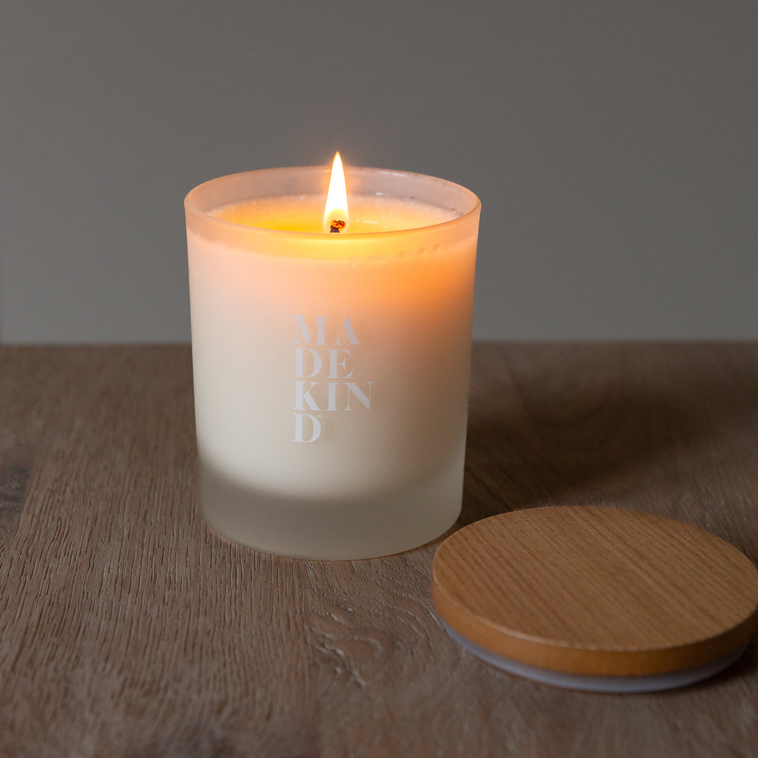 Candle with wooden lid on a wooden surface