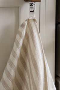 Photo of a hanging white and beige striped woven linen tea towel