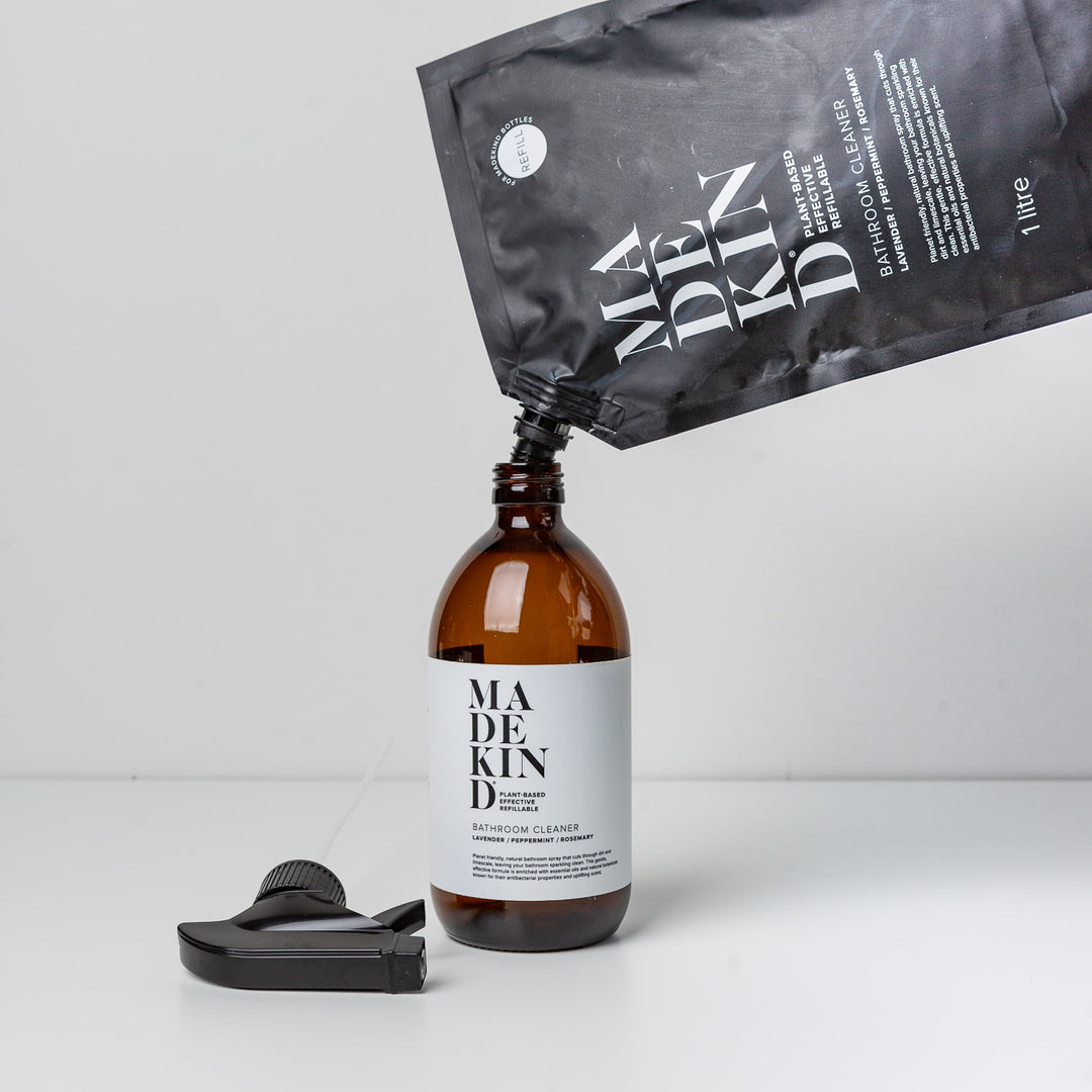 person pouring natural eco-friendly bathroom cleaner into sustainable amber glass bottle