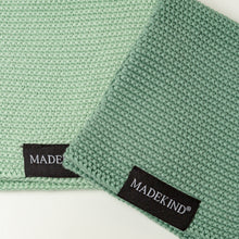 Load image into Gallery viewer, Photo of two green madekind cloths with the logos on the front
