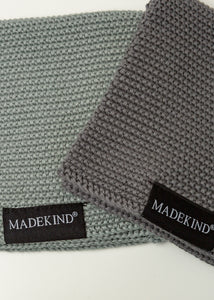 Photo of two grey madekind cloths with the logos on the front