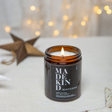 Load image into Gallery viewer, photo of a MadeKind 180ml Wintering soy wax aromatherapy candle with a christmas star in the background
