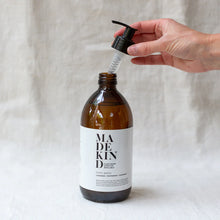 Load image into Gallery viewer, Photo of 500ml empty amber glass bottle for Madekind natural cleaning refills with a hand holding the pump
