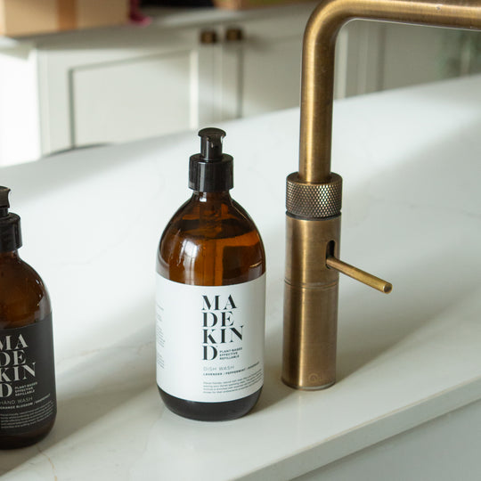 Bottle of MadeKind Dish Wash next to a kitchen sink