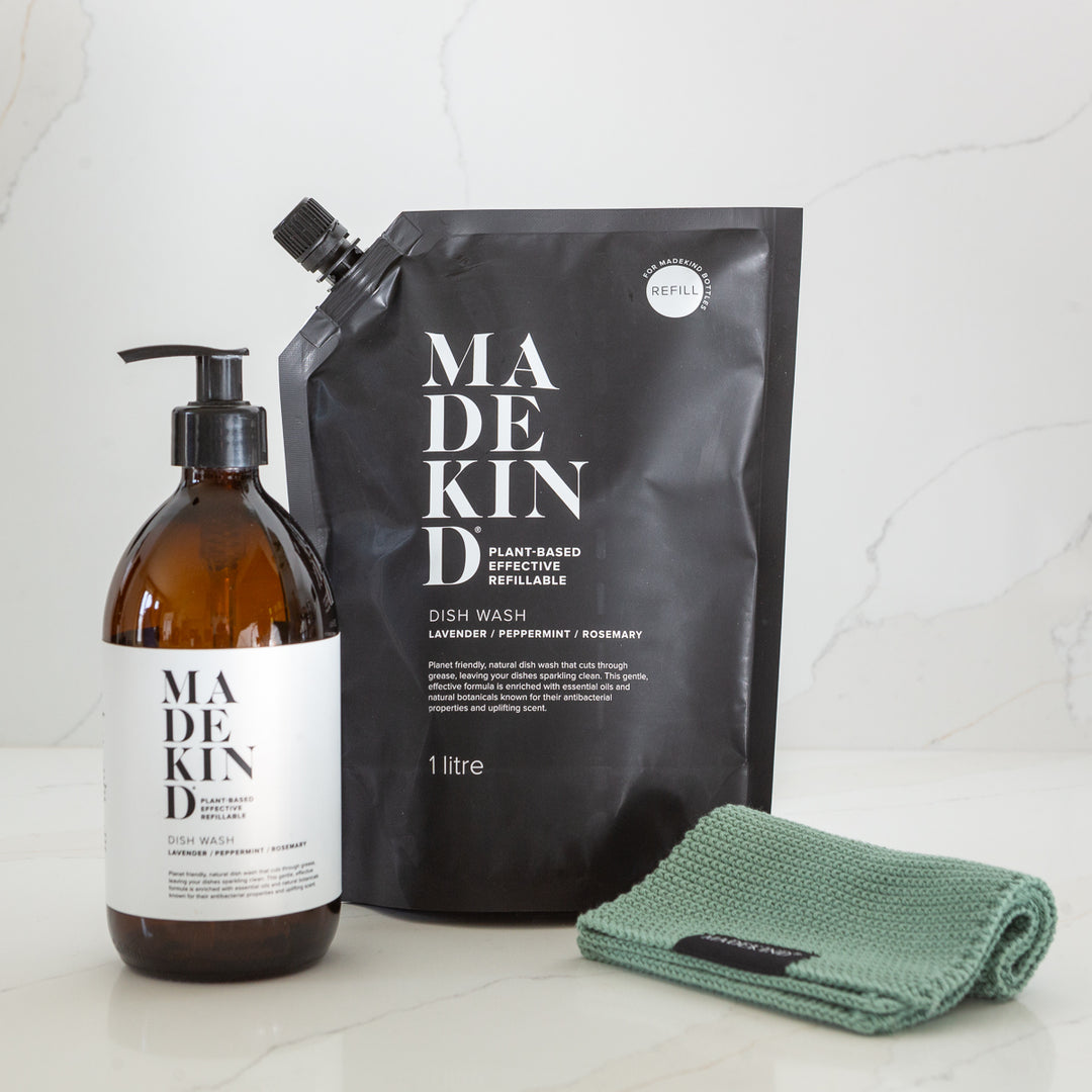 Madekind dish wash bottle, refill pouch, and green cloth on a white surface.