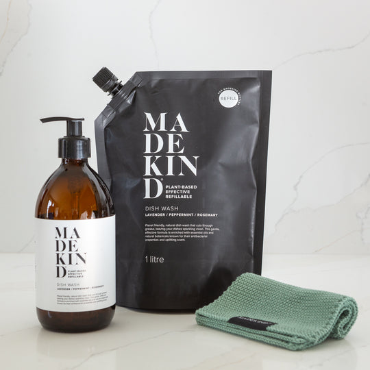 Madekind dish wash bottle, refill pouch, and green cloth on a white surface.