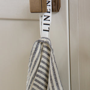 Photo of a Grey Striped Tea Towel hanging from a hook