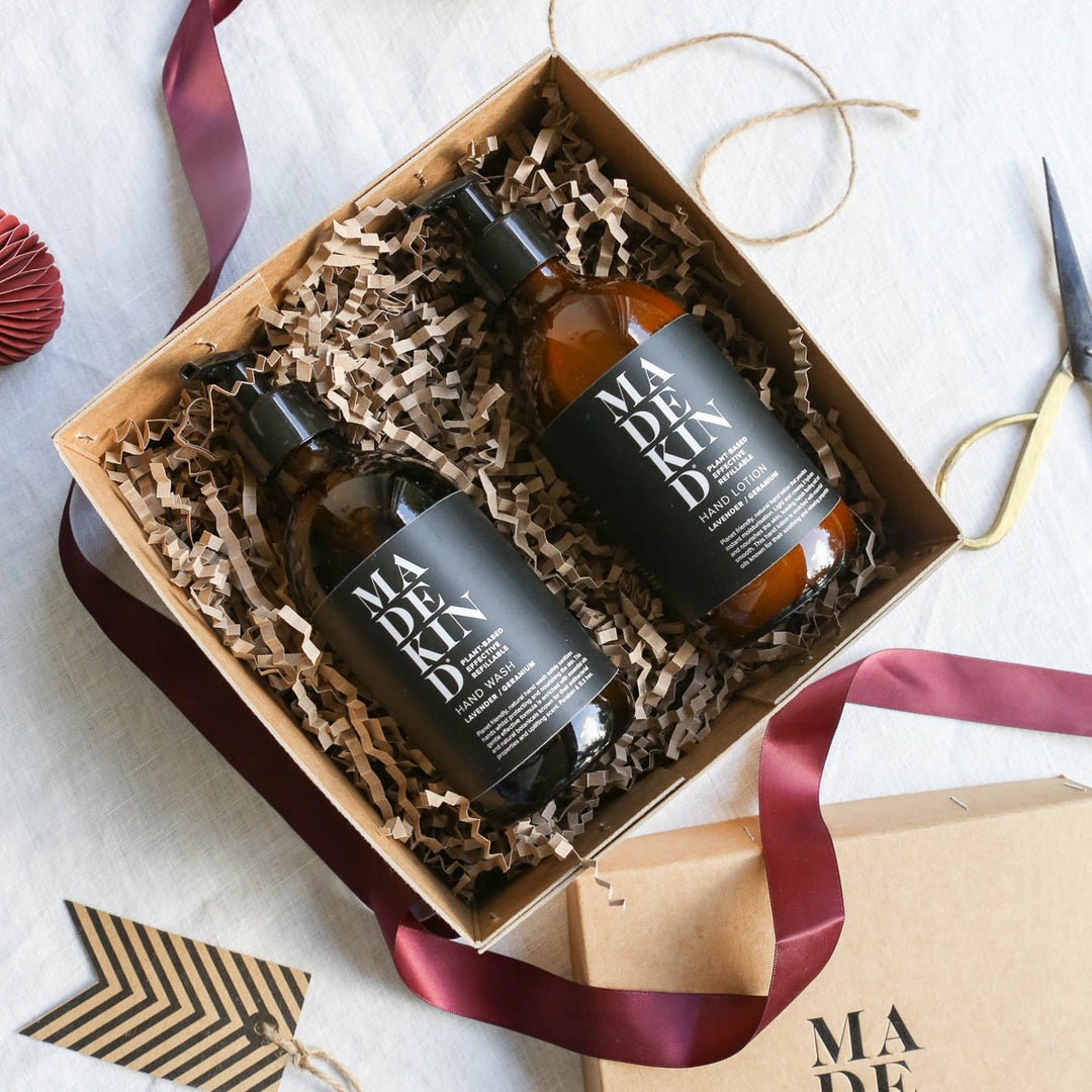 Photo of an open gift box containing a MadeKind Hand Wash and Hand Lotion with festive ribbon and tag
