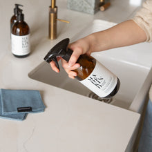 Load image into Gallery viewer, Photo of a hand holding a bottle of Multi Surface Cleaner at a kitchen sink
