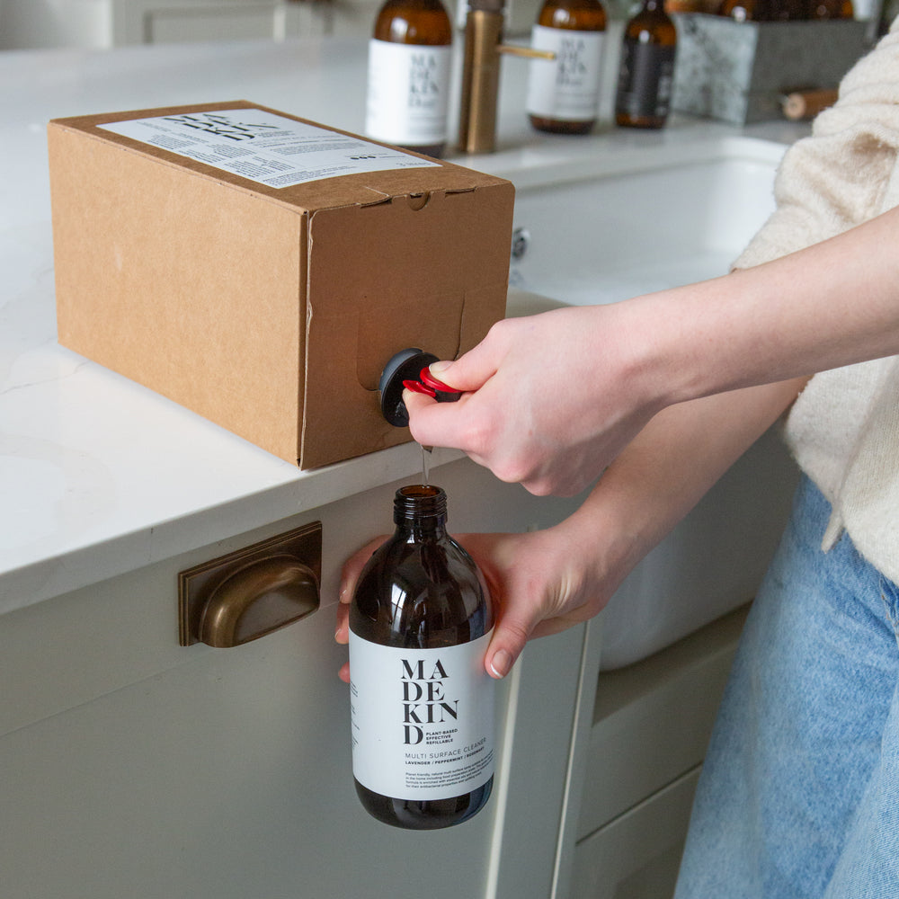 Photo of a MadeKind Multi Surface Cleaner 3 Litre refill tap being pressed to refill a MadeKind forever glass bottle