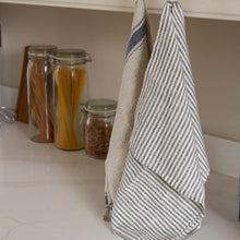 Load image into Gallery viewer, Photo of a woven linen grey striped tea towel and a rustic tea towel hung in a kitchen
