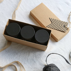 Photo of 3 amber glass soy wax candles in a box with the lid off