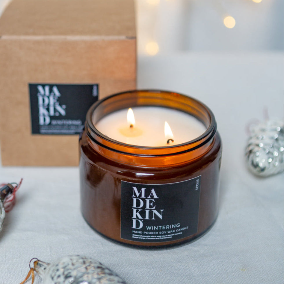 'Wintering' Home Fragrance  soy wax candle in amber glass jar with madekind gift box next to it.