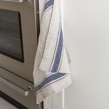 Load image into Gallery viewer, Photo of he madekind blue border striped tea towel next to an oven
