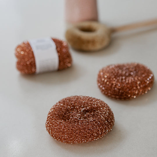 Photo of Redecker copper scourers with a brush in the backdgound